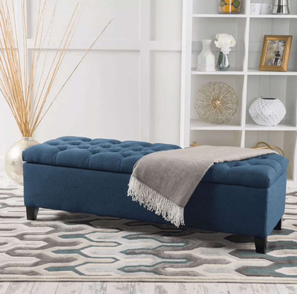 blue storage ottoman with blanket on top