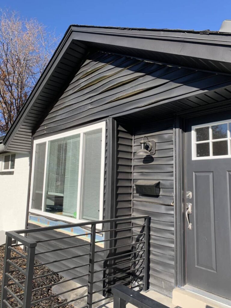 Black vinyl siding warped and faded